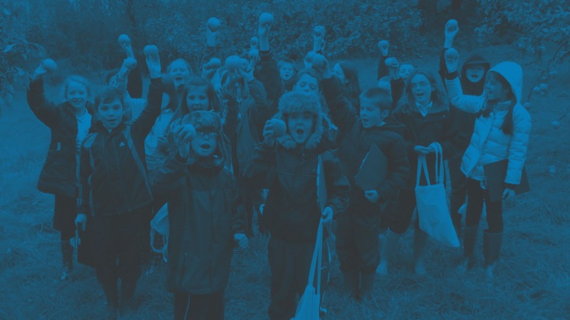 Image of excited children holding apples, from the Tree Council website - Providing funding for planting and care of trees