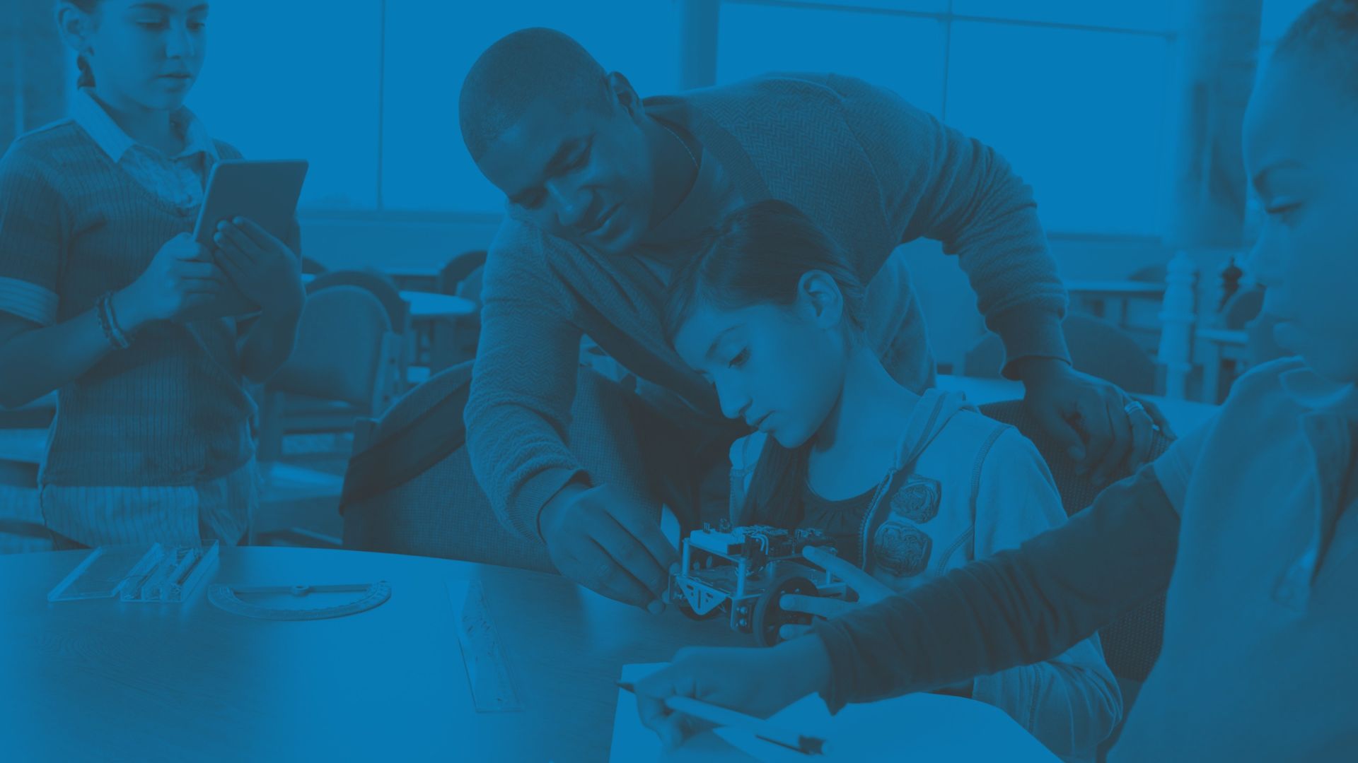 A photograph of a group of primary age children being taught STEM projects in an educational setting - Opportunities for Oval Learning schools to apply for funding
